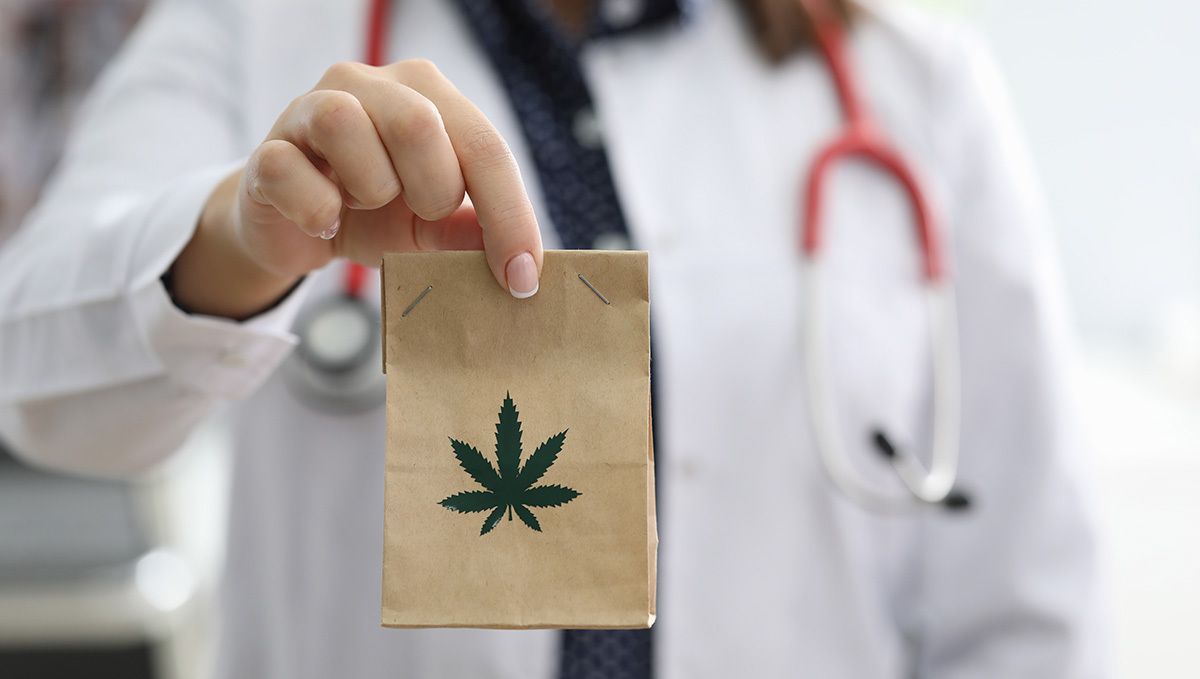 ミシシッピ州（米国）、医療用大麻を合法化：茶色の紙袋（大麻の葉のロゴ入り）を持つ女性医師